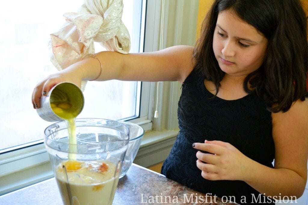 girl pouring eggs over a blender