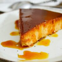 caramel drizzled over pumpkin flan on a white dish