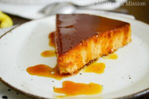 caramel drizzled over pumpkin flan on a white dish