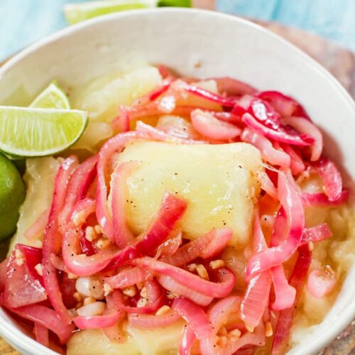 yuca with mojo in a white bowl
