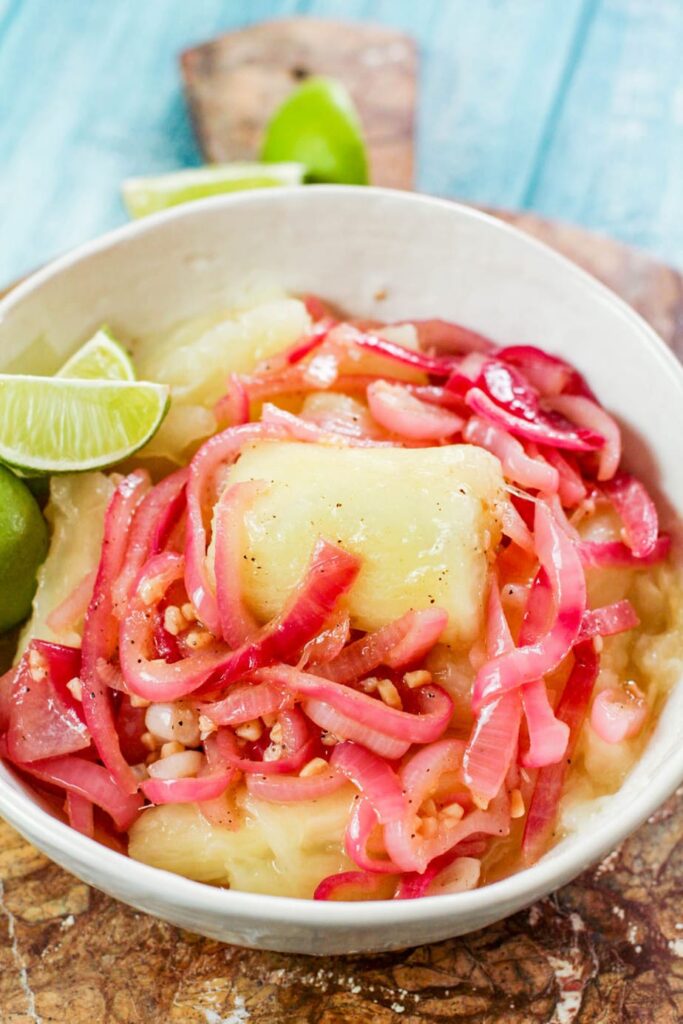 yuca with mojo in a white bowl