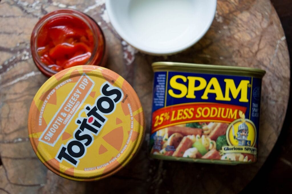 can of spam, cheese dip, and open pimentos on a marble surface