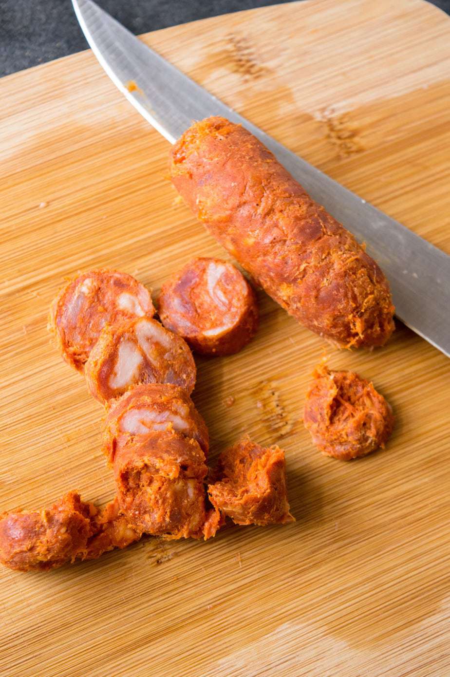 Chopped Spanish chorizo on a wooden cutting board.