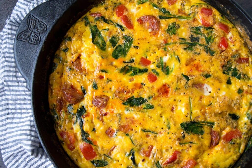 A cast iron pan with a full frittata full of chorizo and veggies.