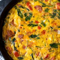 A cast iron pan with a full frittata full of chorizo and veggies.