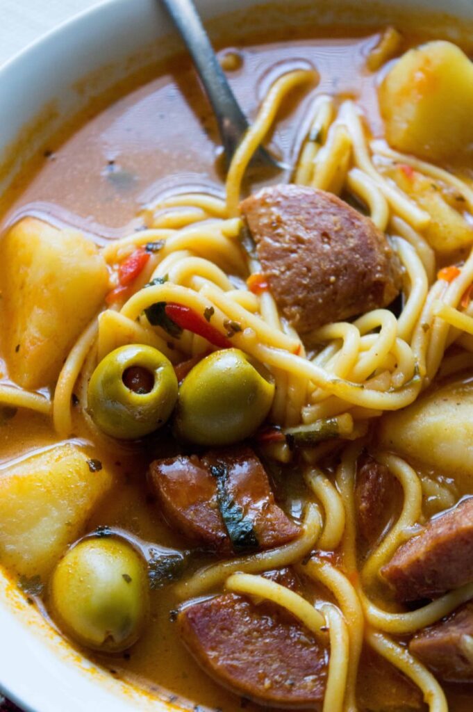 soup with salami and noodles in a white bowl