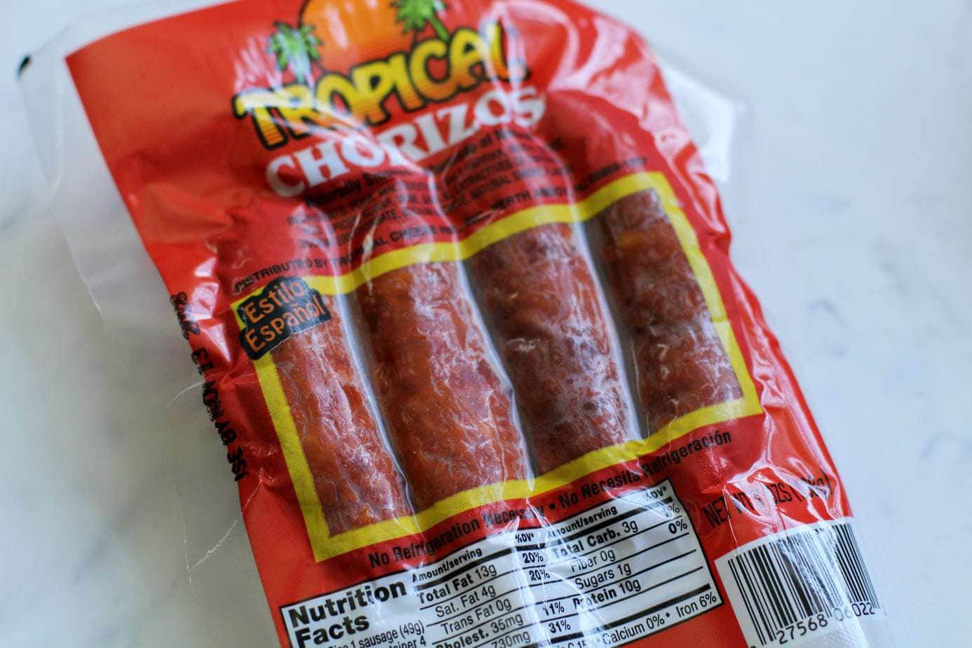 A red package of smoked chorizo from Tropical brand with a gray background.