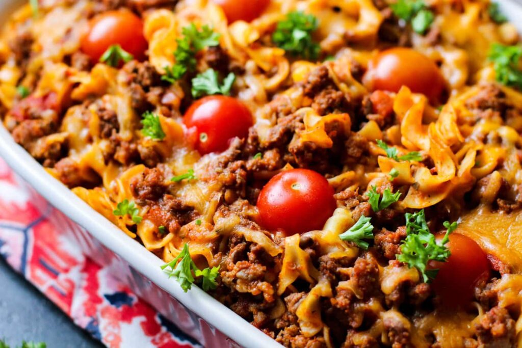 sausage and pasta bake with big fresh tomatoes in a pan