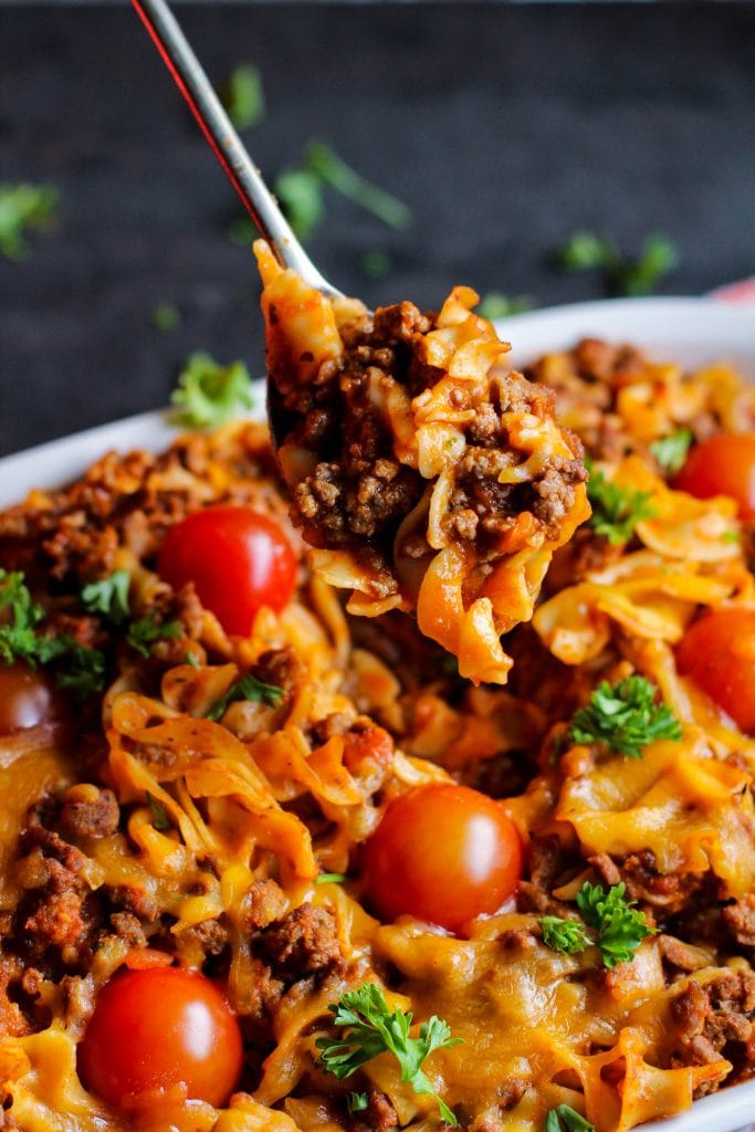 Pasta bake with a spoon and tomatoes