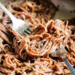 Ropa vieja being shredded with two forks