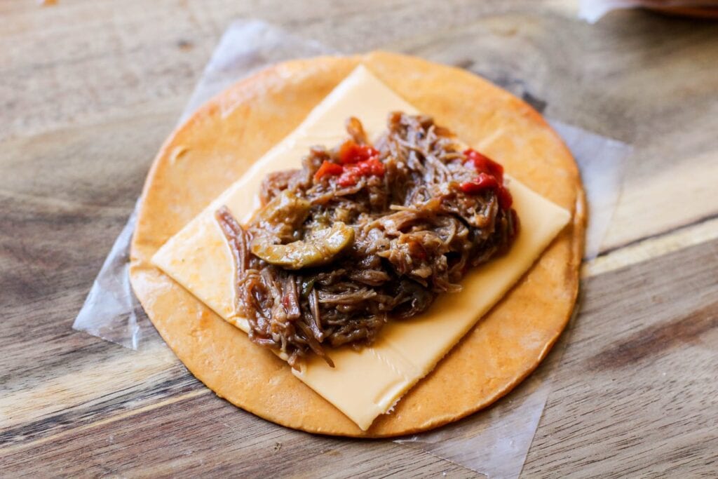 Unrolled ropa vieja empanada on a cutting board