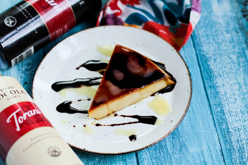 slice of flan with chocolate and vanilla syrup on a white plate