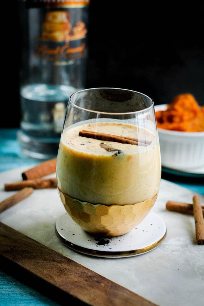 Puerto Rican coquito in a glass cup with cinnamon sticks