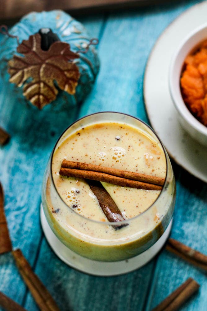 Close up shot coquito with creamy pumpkin and cinnamon sticks