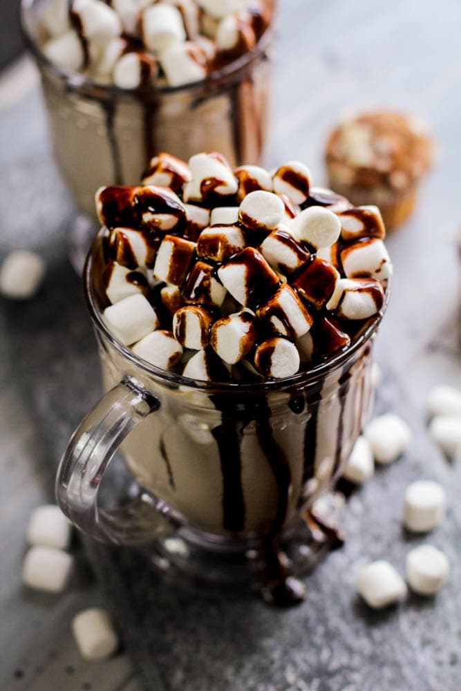 chocolate and marshmallows overflowing in a glass cup