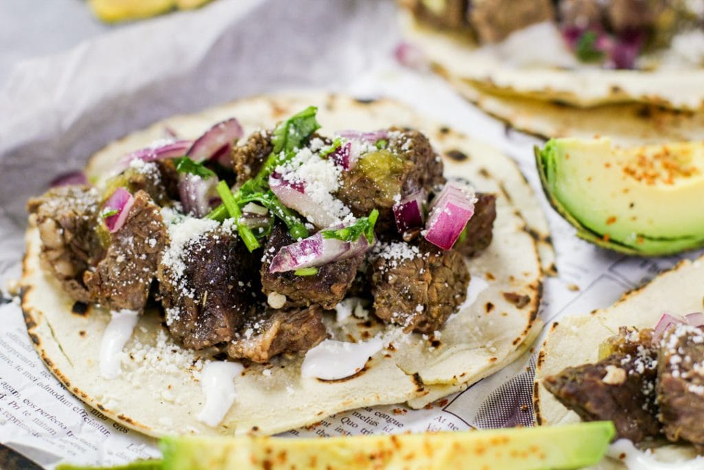 barbacoa beef tacos with onions and cilantro