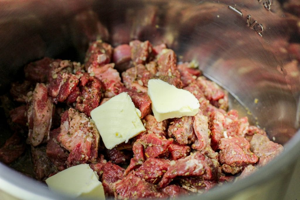 uncooked steak and butter in the Instant Pot