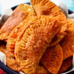 a pile of empanadas in a big bowl
