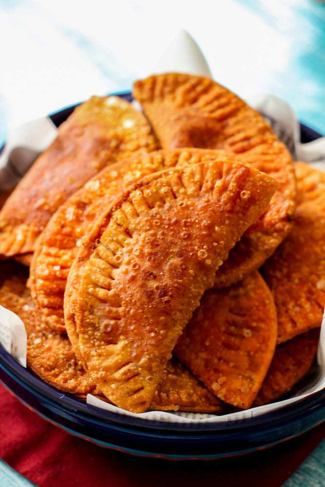 a pile of empanadas in a big bowl