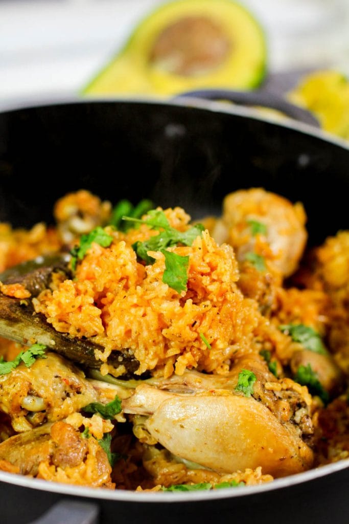 Spanish rice garnished with cilantro on a wooden spoon.