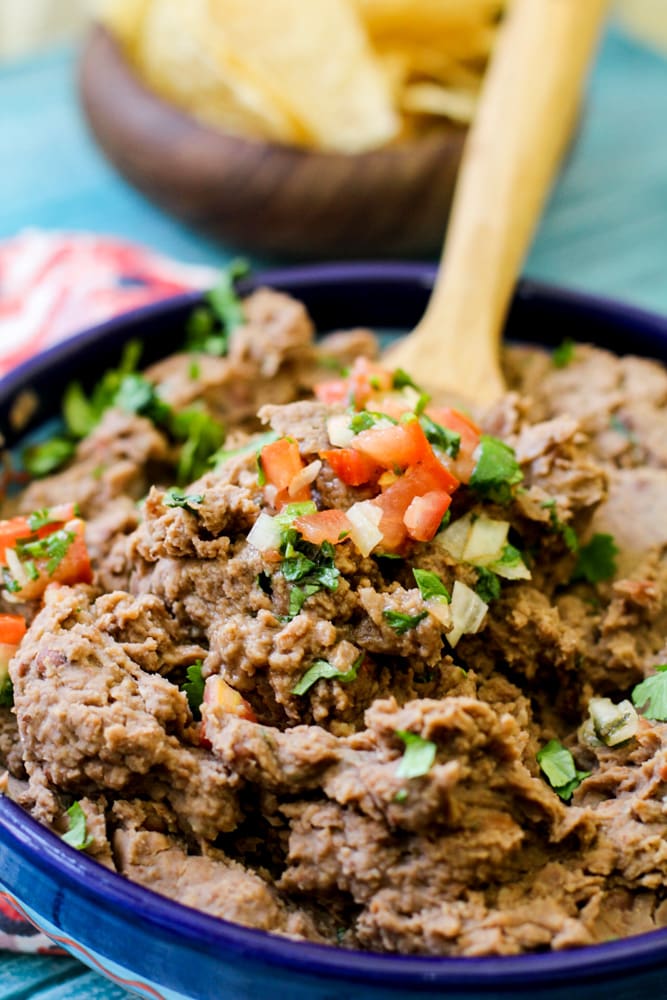 refried beans on a wooden spoon