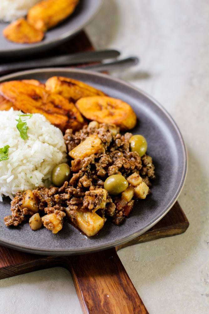 picadillo with write rice and plantains on a gray plate