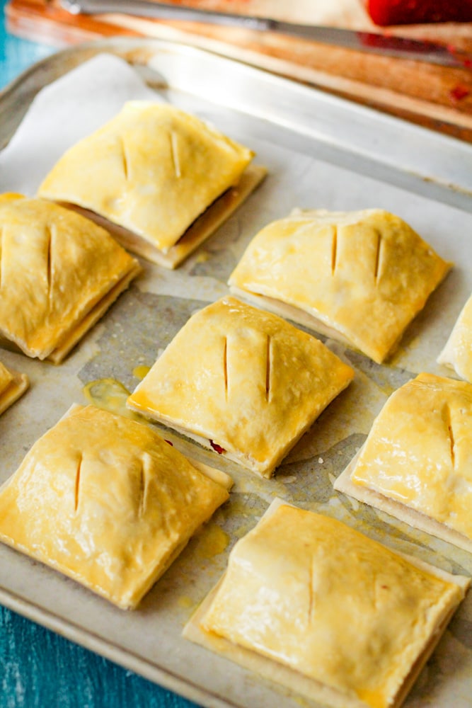 Guava and Cheese Pastry | Pastelitos de guayaba y queso on a tray with scores on top