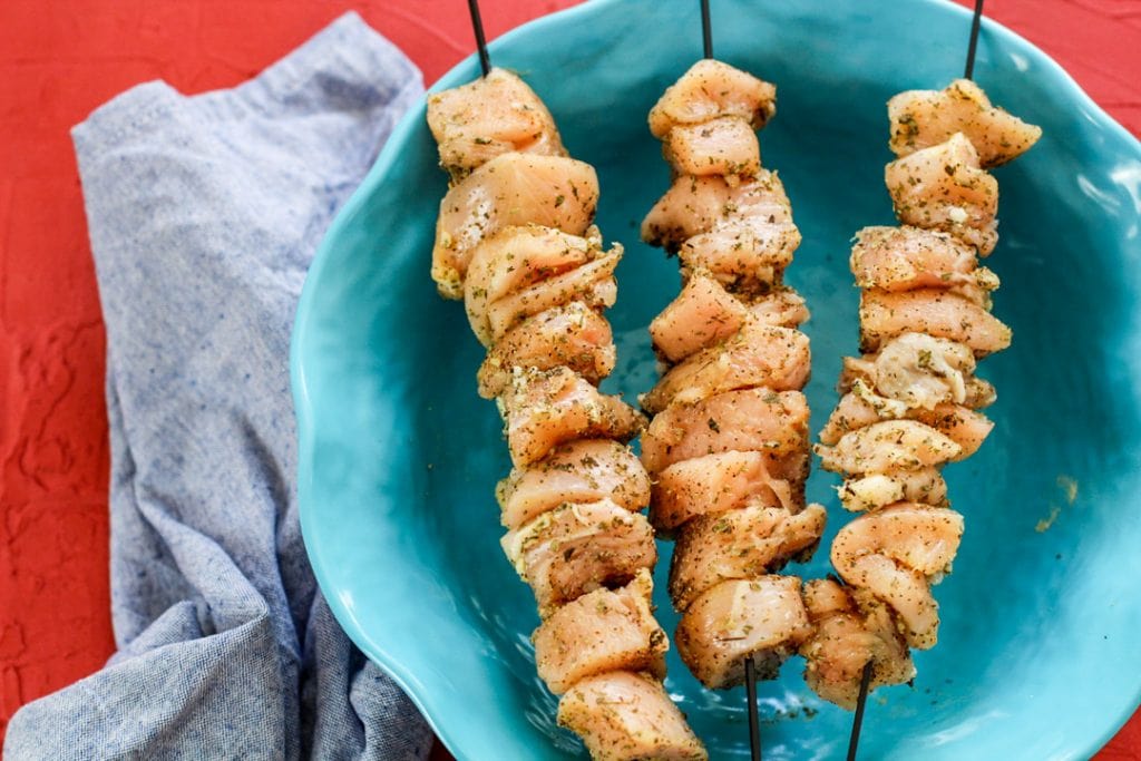 raw seasoned chicken on skewers