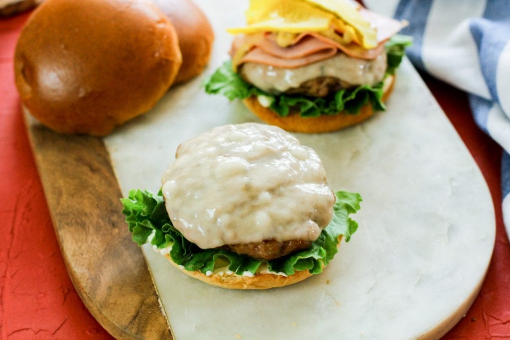 Cuban burger with cheese on lettuce and bread