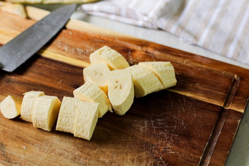 peeled and chopped green plantains on a cutting board