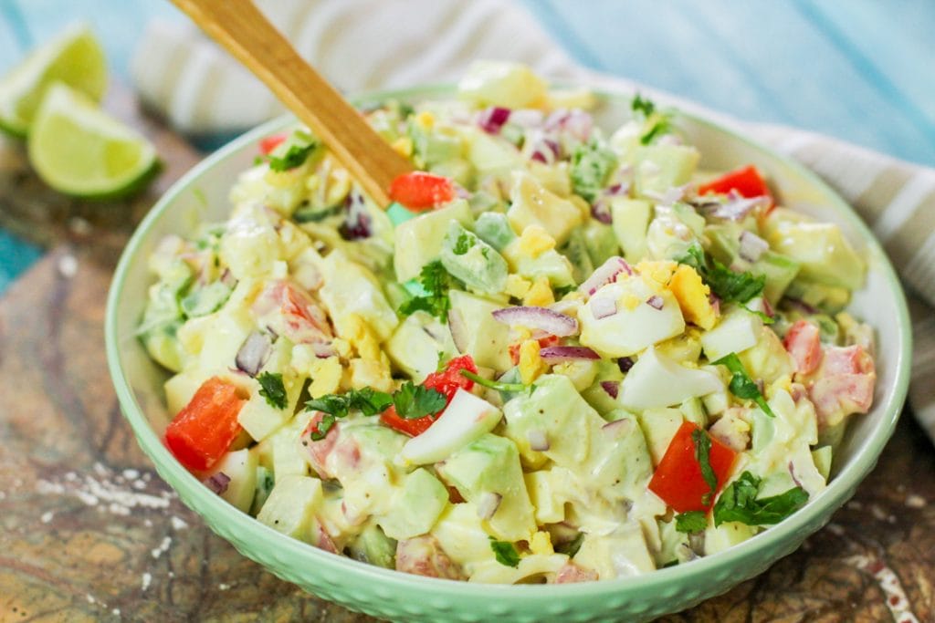 chayote egg salad with a wooden spoon in a bowl