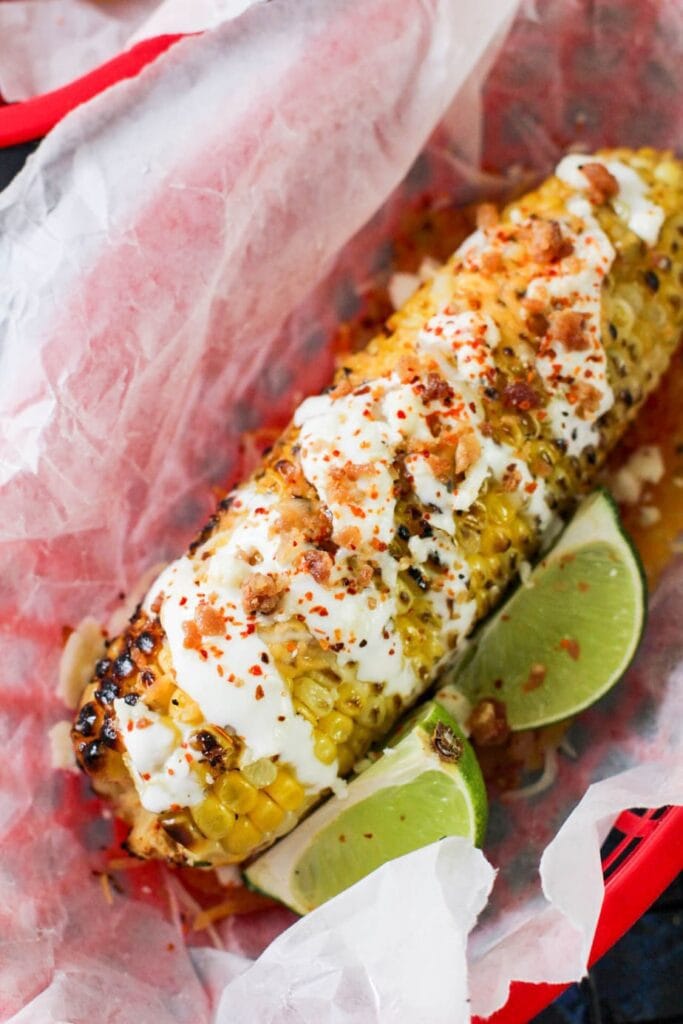 corn with sour cream and lime wedges