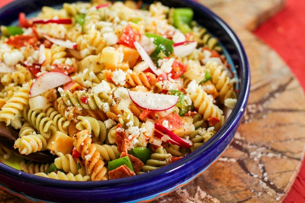 spicy pasta salad in a bowl on a brown background