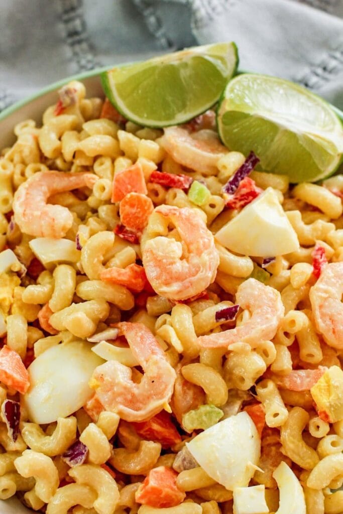 shrimp with limes in a bowl with macaroni noodles