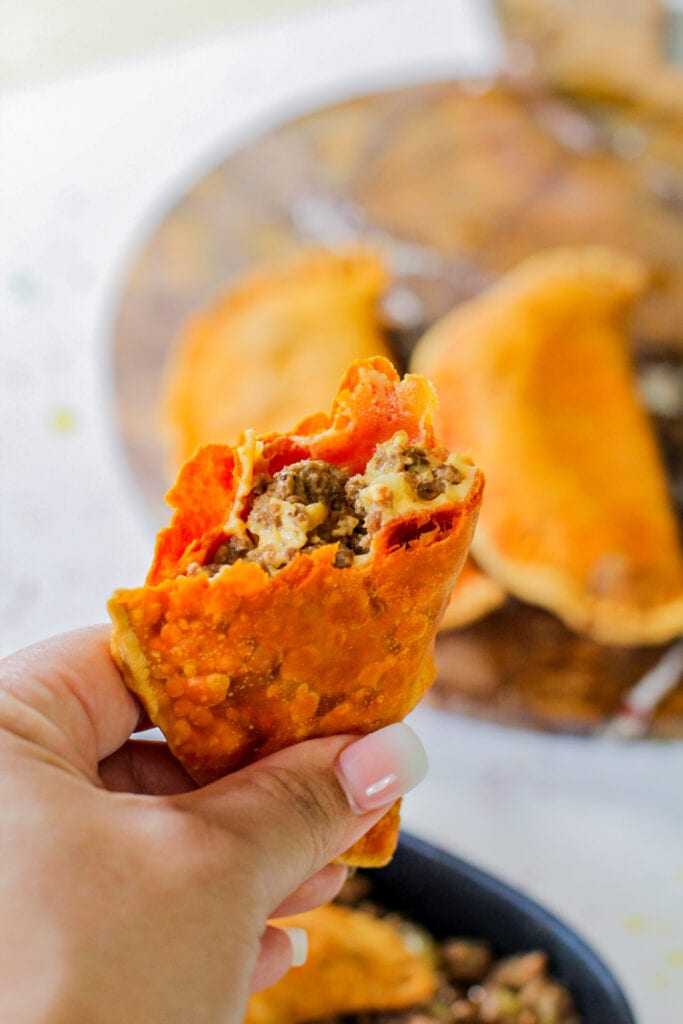 cheesy beef picadillo held up by a hand