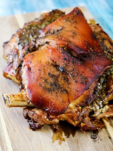 cooked pernil on a wooden cutting board