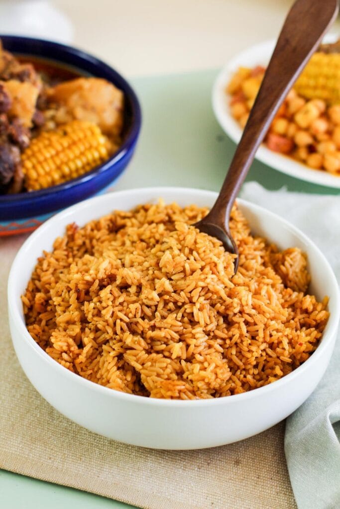 wooden spoon lifting yellow rice from white bowl