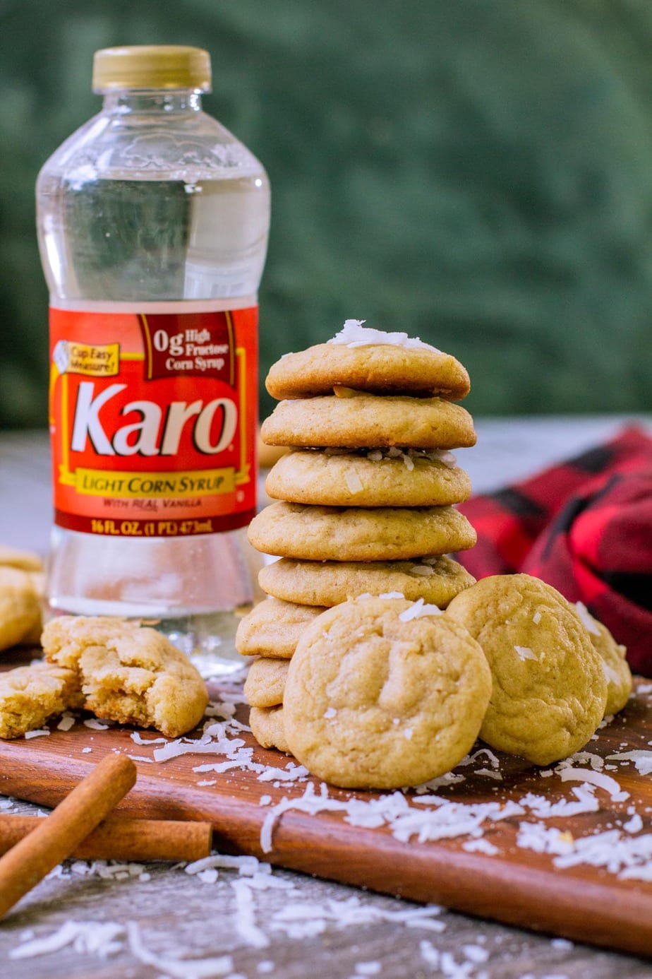 A tower of coconut cookies over a wooden serving board.