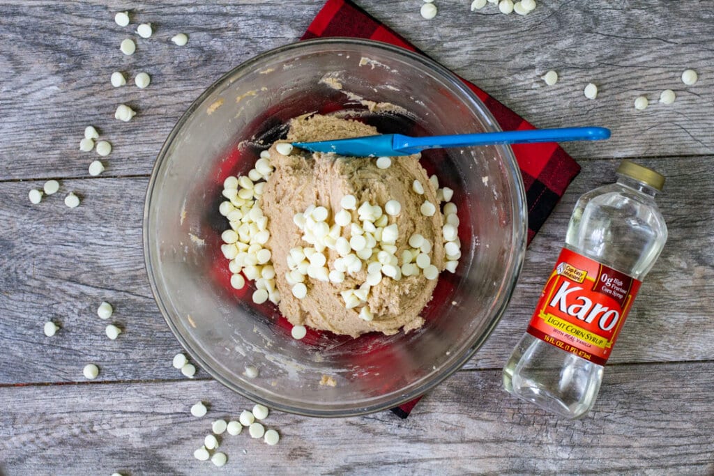 white chocolate chips and raw cookie dough in glass bowl