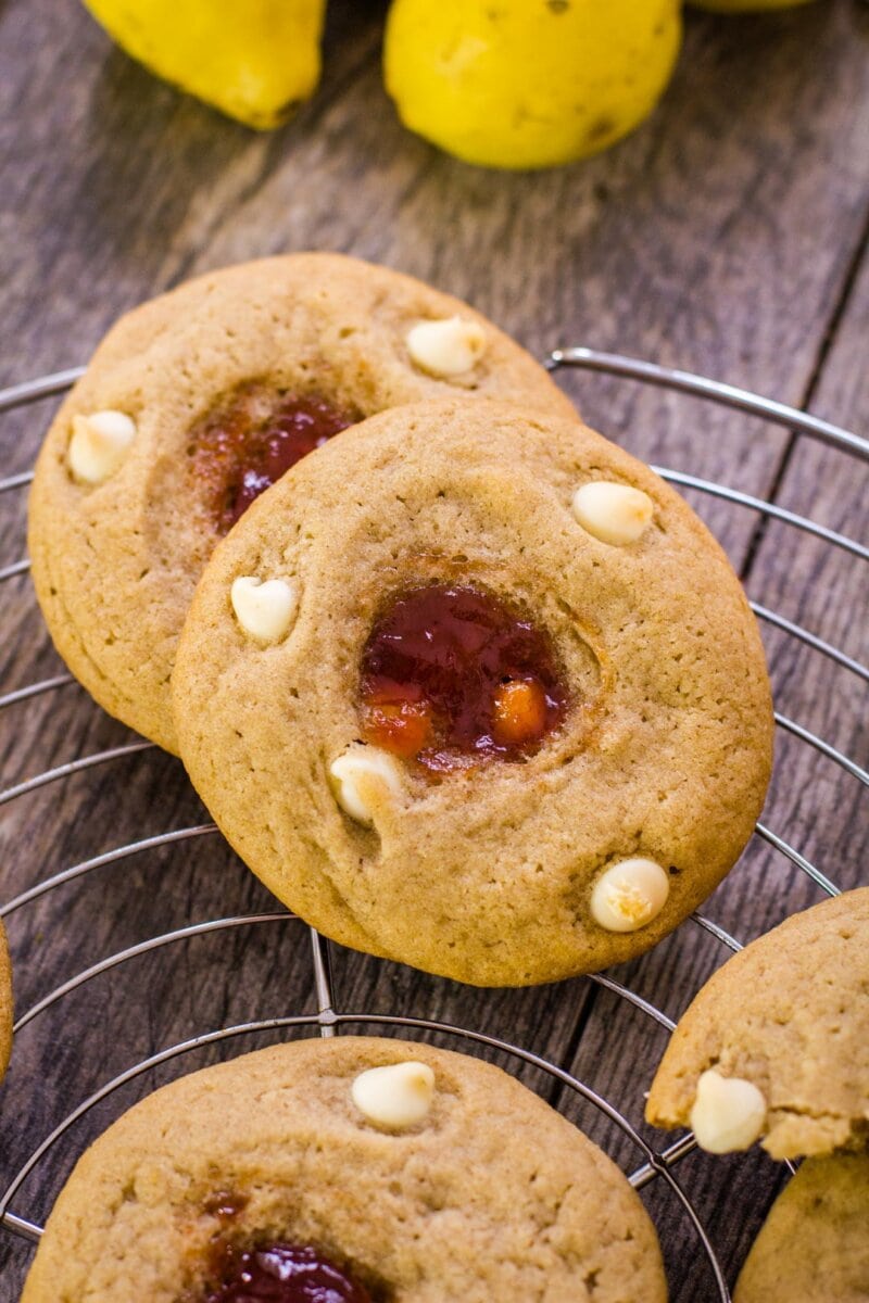 guava sugar cookies with white chocolate chips lined up on a wire rack