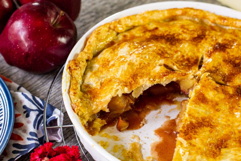 baked apple pie in a white pie plate