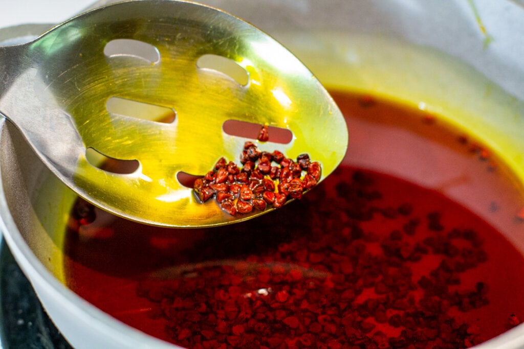 metal spoon with achiote oil on the spoon