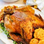 Whole turkey on a white platter with plantains