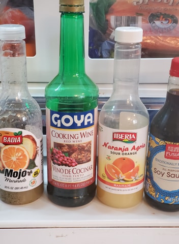 containers of cooking wine, soy sauce, and mojo in a fridge