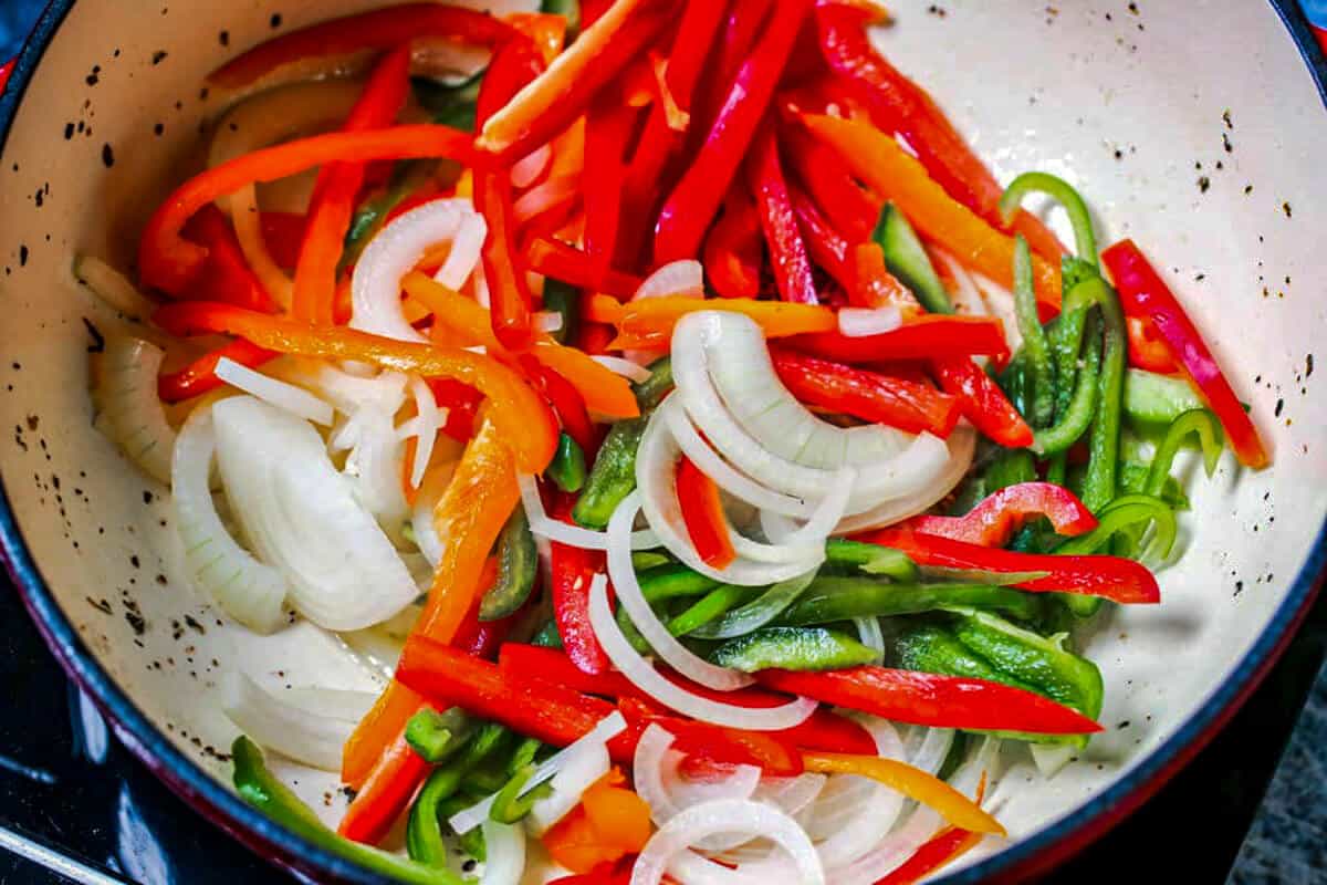 Raw onions and peppers in a pan.