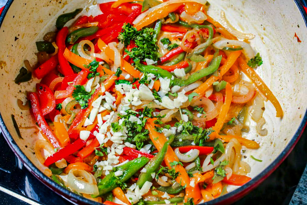 Sauteed vegetables in a pot for pork chop spaghetti.