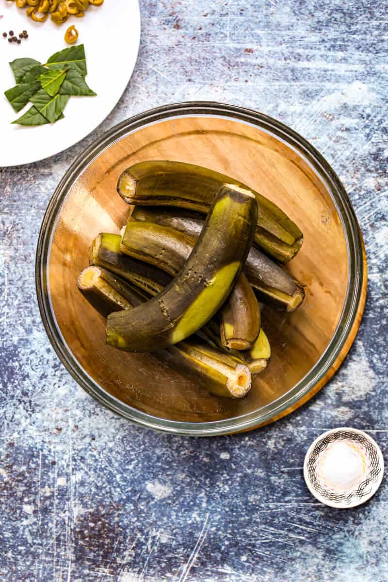 Cooked green bananas cooling in a glass bowl.