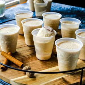 A group of frozen limbers are on a wooden platter with cinnamon sticks on the tray.