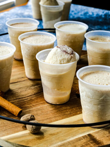 A group of frozen limbers are on a wooden platter with cinnamon sticks on the tray.