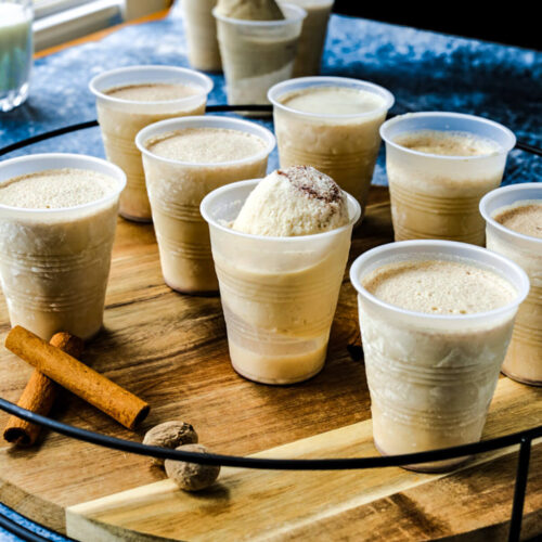 A group of frozen limbers are on a wooden platter with cinnamon sticks on the tray.